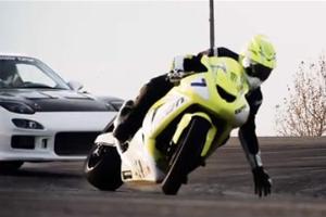 Nick Brocha drifting on a modified Kawasaki ZX-10 doing an angled lean where he nearly touches the asphalt with his gloved fingers